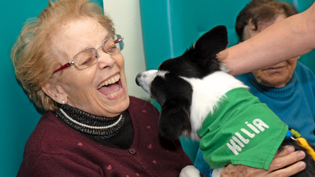anziana sorridente durante pet therapy con cane co-terapeuta progetto Killia in centro per anziani